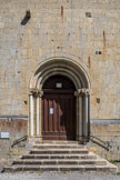 <center>Notre-Dame-de-Valvert.</center>La porte en plein cintre, sans tympan est précédée de six degrés. Elle est munie de voussures toriques à trois ressauts retombant de chaque côté sur deux colonnettes à socle mouluré, par l'intermédiaire de chapiteaux formant frise, taillés dans un seul bloc. Deux corbeaux en pierre sont visibles au-dessus de la porte au niveau de la septième assise.