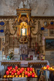 <center> Castellane. Chapelle Notre-Dame-du-Roc.</center> Autel constitué d'un tombeau droit en retrait, et de trois gradins, le dernier incluant le tabernacle. En avant du tombeau, quatre fines colonnes soutiennent une table d'autel constituée de plusieurs planches en bois assemblées avec un décor ajouré peint faux or formant corniche pour les colonnes.