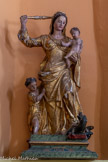 Chapelle Saint Joseph. Vierge à l'Enfant et saint Jean Baptiste terrassant le dragon. Sur un socle peint en faux marbre vert veiné, la Vierge est représentée tenant l'Enfant dans ses bras et accompagnée de saint Jean Baptiste enfant, blotti contre elle. Marie foule au pied un dragon et le menace d'un sceptre en balustre. La sculpture est faite de deux parties principales. Une seule grume de bois fut taillée pour obtenir les figures. L'ensemble est complété par des éléments rapportés, notamment le bras dextre de la Vierge et son instrument, mais aussi le museau et le buste du dragon.