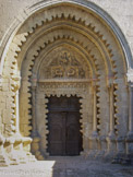 <center>Abbaye Notre-Dame de Ganagobie.</center> Le tympan, cantonné d'un cordon de bâtons brisés, est orné d’un Christ en majesté, dans une mandorle, encadrée du Tétramorphe (symboles des quatre Évangélistes), le tout en bas-relief. Les douze apôtres sont sculptés sur le linteau. les lobes se détachant des voussures sont tout à fait uniques et « extravagants ».