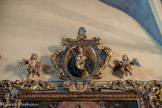<center>Saint-Sauveur-sur-Tinée </center>  L'encadrement s'interrompt au sommet pour accueillir un médaillon daté de 1744, figurant une Vierge de Douleur au cœur percé d'une dague, entouré d'un double rameau fleuri, porté par un séraphin et flanqué de deux angelots.