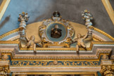 <center>Saint-Sauveur-sur-Tinée </center>  Retable du Rosaire. Les chapiteaux composites portent une architrave très classique, ornée de rinceaux et de séraphins, sur laquelle se développe un fronton en arc de cercle interrompu portant deux vases à bouquet et habité d'angelots qui présentent, sous un vase plus petit, un médaillon avec la figure de saint Dominique vêtu de bure et tenant en mains le chapelet du Rosaire.