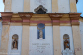 <center>Roure. </center> Au-dessus de la porte, une inscription « Sancte Laurenti intercède pro nobis » (« Saint Laurent intercédez pour nous »), surmontée de la statue du saint, portant la palme du martyre et accompagné de l’instrument de son supplice, un gril. Deux niches latérales abritent les statues d’un saint évêque et d’une sainte, parfois identifiée comme Sainte-Claire (?).