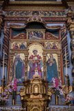 <center>Roure. </center> Le polyptyque, au-dessus du maître-autel, montre, dans son panneau central, St Laurent, portant la dalmatique, l’habit liturgique des diacres, avec son attribut, un gril. Né en Espagne (ou à Rome ?), archidiacre du pape St Sixte II et chargé des biens de l’Eglise, il est, selon la légende, supplicié sur un gril pour lui faire livrer les Livres Saints et les richesses dont il avait la garde mais qu’il avait distribuées aux pauvres sur ordre du pape. A ce double titre, il est considéré comme le patron des pauvres et des archivistes, Il fut l’un des martyrs les plus populaires de la chrétienté. Il est réputé guérir les brûlures et prévenir les incendies.