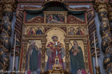 <center>Roure. </center> St Laurent est encadré, à gauche, par St Grat, évêque d’Aoste au Ve siècle, portant la tête de St Jean- Baptiste, qu’il aurait retrouvée dans un puits en Palestine, selon une légende tardive du XIIIe siècle. Il est vénéré comme guérisseur et comme protecteur des récoltes contre les tempêtes et la grêle. A droite, Ste Pétronille. Romaine, considérée comme la fille spirituelle de St Pierre, elle préféra mourir plutôt que d’épouser un noble romain. Elle devient, à partir de Charlemagne, la patronne des rois de France puis la première sainte patronne du royaume. Au-dessus, à gauche, Ste Lucie, jeune fille noble de Syracuse, martyre au IVe siècle. En référence à un épisode de son supplice, elle est représentée portant ses yeux sur un plateau. A côté d’elle, St Antoine l’Ermite, chrétien égyptien, IIIe - IVe siècle, retiré au désert pendant plus de 70 ans. Représenté avec une clochette, comme le veut une tradition sans fondement avec ce que nous connaissons de sa vie. A droite, St Martin, évêque de Tours au IVe siècle. A son côté, Ste Apolline d’Alexandrie, représentée avec des tenailles, instruments de son supplice. Parce qu’elle refusait de blasphémer, on lui arracha les dents. Elle se précipita ensuite, elle-même, dans le bûcher, préparé à son intention par ses bourreaux. Au sommet, Déploration du Christ. Autour du corps, à l’aspect cadavérique saisissant : St Jean l’Evangéliste, Marie et Ste Marie-Madeleine.
