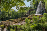 <center>Le Jardin des Fontaines Pétrifiante</center> En provenance du plateau des Chambarans quelques ruisseaux se perdent dans le sol très calcaire de la plaine de St-Marcellin. Durant leur trajet souterrain ces eaux chargées de dioxyde de carbone circulent sous pression à travers les couches de roches. Cette particularité leur confère une légère acidité qui leur permet de dissoudre très facilement le calcaire. Dès leur apparition à l'air libre le gaz s'échappe, le calcaire dissout réapparait et se dépose sur le premier obstacle rencontré.
En particulier sur les mousses qui sont recouvertes à la base mais continuent de pousser. Le tuf est le nom donné à cette roche formée par des végétaux pétrifiés. Ces sources renferment plus de 315 mg /I de calcaire. Cette propriété permet au tuf de s'accroître de plusieurs centimètres par an