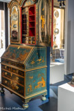 <center>Bureau-bibliothèque</center>L’ensemble de la surface vernissée figure un décor de chinoiseries : à l’intérieur des vantaux, se tiennent deux Chinois stéréotypés, tandis que des motifs de maisons pittoresques sont représentés sur l’abattant du bureau. Si la nature de la laque reste à définir, cette couleur bleue, inconnue en Asie avant le XIXe siècle, est en revanche très usitée dans l’Angleterre du XVIIIe siècle. L’ensemble de ces caractéristiques nous autorise à penser qu’il s’agit certainement d’une fabrication anglaise.
