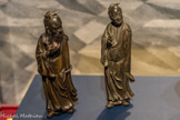 <center></center>De gauche à droite. Dongfang Shuo
Chine. Fin dynastie Ming (1368-1644). Bronze, traces de polychromie, crin. L’immortel taoïste Dongfang Shuo (154-93 av. J.-C.) aurait été le bouffon du roi, appelé en 138 av. J.-C. par l’empereur Wudi (r. 141-87 av. J.-C.) des Han de l’Ouest (206 av. J.-C. - 9 ap. J.-C.) pour distraire la cour de Chang’an [actuelle Xi’an], dans la province du Shaanxi. La légende raconte qu’il aurait volé les pêches d’immortalité du jardin de la reine-mère de l’Occident, la déesse chinoise Xiwangmu dont il tient ici un des fruits contre sa poitrine. Des traces de polychromie révèlent le fruit défendu et renforcent la préciosité de l’objet du vol. L’usage de cheveux naturels pour marquer la pilosité permet également de donner vie au personnage. La pilosité relève d’une fonction spirituelle et symbolique.<br>
Lü Dongbin. Chine. Fin dynastie Ming (1398-1644). Bronze. Lü Dongbin compte parmi les plus populaires des huit Immortels baxian (adeptes du taoïsme), qui font l’objet d’un culte encore répandu de nos jours, vénérés comme dieux du bonheur et de la prospérité. Les Immortels sont au début de leur vie des êtres humains ; des transformations physiques et spirituelles les conduisant à un état transcendantal. Esprits libres, modèles de vertu, ils font le lien entre le ciel et la terre.<br>Don Marie Grobet, 1919. Marseille, Musée Grobet-Labadié.