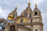 <center>La cathédrale Saint-Alexandre-Nevsky</center>Le tympan est orné d’une copie d’une oeuvre du Ve siècle représentant le Christ Pantocrator. La flèche centrale (48 m) ainsi que les quatre autres flèches sont surmontées d’un bulbe doré. Les cinq bulbes symbolisent le Christ et les quatre évangélistes.