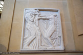 <center>La Tragédie</center>Bas-relief pour le Théâtre des Champs-Élysées
1912
Plâtre
Don Cléopâtre Sévastos Bourdelle et Rhodia Dufet Bourdelle. 1949.<br>
La figure féminine de La Tragédie est-elle inspirée de l’Iphigénie du poète Jean Moréas représentée en 1903 à l’Odéon ? Ou de l’apparition magnétique de la danseuse Isadora Duncan dans Iphigénie en Tauride de Christoph Willibald Gluck, conservée par Bourdelle «en trait d’éclair dans [sa] mémoire » ?
La stylisation ondulante de la chevelure et des draperies s’inscrit dans la loi inflexible du cadre et des lignes architecturales de la façade, répercutées au sein du bas-relief par la double horizontale des bras repoussant la verticalité du gla