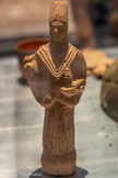 <center>PRÊTRE PORTANT UN BRÛLE-P ARFUM</center>Période romaine, IIe-IIIe siècle
Terre cuite.
Cette statuette représente un personnage tenant un brûle-parfum composé d’un long manche et d’un brûleur surmonté d’une tête de sphinx portant la double couronne égyptienne. La main droite, aujourd’hui disparue, suggère un geste de bénédiction. Cette pièce s'apparente au thème du prêtre offrant le précieux encens. Gaza dans l’Antiquité était notamment connue pour être l’aboutissement de la mythique route de l'encens reliant les ports d'Oman et du Yémen à Gaza.