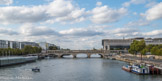 <center>La passerelle Simone-de-Beauvoir. </center>Pont de Bercy. Le pont en arc encastré, à multiples travées a été construit entre 1863 et 1864, surélevé en 1904, élargi entre 1989 et 1992. Il a été inauguré en 1864. A gauche, la piscine flottante Joséphine-Baker, inaugurée une semaine avant la passerelle (6 juillet 2006).