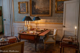 <center>Chambre de Monsieur Thierry de Ville-d'Avray</center>Bureau plat néoclassique à cinq tiroirs sur quatre pieds fuselés, cannelés et rudentés. L'ensemble est enrichi de bronzes dorés en chutes comme rudentures sur les pieds ainsi qu'aux angles de la ceinture formant triglyphes. Le plateau couvert de cuir est cerclé de bronze, comme les prises rondes des tiroirs. On note un plateau en tirette sur l'autre face en ceinture. 1750-1799.