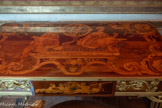 <center>Cabinet doré.</center>La table est couverte d'un tableau de marqueterie représentant les allégories de l'Astronomie et de la Géométrie, accompagnées d'une sphère armillaire. Les angles sont occupés par une rosace entourée de rinceaux.