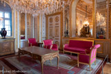 <center>Salon diplomatique</center>Canapé en hêtre sculpté et doré reposant sur huit pieds cylindriques bagués soutenant la traverse bombée et ornée de trois motifs de rosette et fleurons. Les consoles d'accotoirs prolongent les pieds antérieurs en cylindres fuselés, terminés par une rosette en plateforme. Les accotoirs sont garnis en plein et munis de manchettes. Le dossier unique est d'aspect rectangulaire, bordé de montants en méplats discrètement sculptés et couronné d'un léger fronton à rinceaux. L'assise est garnie à carreau et le dossier en plein, le tout couvert de soie rouge moirée bordée d'un galon.  Pierre-Benoît Marcion.  1800-1817.