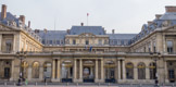 <center>Le Palais Royal.</center> Entrée du Conseil d'État. C'est en 1629 que Richelieu fit construire ce palais par Jacques Lemercier. C'est là qu'il mourut le 4 décembre 1642 et il le légua  à son souverain. À la mort de Louis XIII, Anne d'Autriche s'y installa avec le petit Louis XIV alors âgé de cinq ans et son frère Philippe. De Cardinal, le palais devenait Royal. En 1672 Louis XIV le remet à Philippe d'Orléans, et depuis cette époque, les Orléans en furent les propriétaires. Le Palais présente en façade sur la Place du Palais-Royal, un portique de neuf baies, flanquées de colonnes toscanes reliant deux pavillons à frontons triangulaires. Au fond de la cour s’élève le corps de bâtiment à deux étages surmonté d’un attique avec fronton arrondi où deux génies, de Pajou, soutenaient l’écu des Orléans – actuellement une horloge.