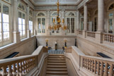<center>Conseil Constitutionnel.</center> Le grand escalier d'honneur est une œuvre de Fontaine (1829 – 1831), il présente une volée centrale qui se divise en deux volées droites ornées de stucs. Les colonnes sont ioniques.