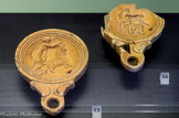 <center>Lampes</center> La nymphe Amalthée saisit la corne de la chèvre qui allaita Zeus enfant. Céramique Produite en Egypte. Milieu du 1er s.
Zeus accompagné d'un aigle tient le foudre abaissé (arme et attribut du dieu). Céramique Produite en Egypte. Milieu du 1er s.