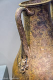 <center>Vase à deux anses</center> Les anses portent un décor raffiné d'animaux hybrides à queue de dauphin et tête de canidé aux yeux incrustés d'argent. Bronze, incrustation d'argent. Première moitié du Ier s.