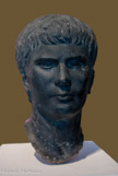 <center>Portrait d'Agrippa Postumus Vers 4 apr. J.-C. Découvert à Alexandrie (Egypte) (?) Basanite</center>Agrippa Postumus (12 av. J.-C. - 14 apr. J.-C.) était le petit-fils de l'empereur Auguste. Après la mort prématurée de ses deux frères, il fut le dernier descendant direct d'Auguste à pouvoir devenir empereur. Mais, pour des raisons qui demeurent peu claires, le jeune prince tomba en disgrâce et fut exilé en 7 apr. J.-C. sur une petite île de la côte italienne où il fut mis à mort sur l'ordre de Tibère, après le décès d'Auguste. Dans ce portrait, Agrippa Postumus montre une contenance assurée, comme son père Agrippa. Le front bas et des sourcils marqués lui confèrent une expression déterminée, voire butée.