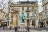<center>Place du Forum.</center> Hôtel Nord-Pinus et statue de Mistral, de Th Rivière, 1909, entourée d'une grille dont les barreaux sont en forme de trident des gardians (ficheiroun).