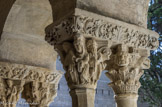 <center>Cloitre de St Trophime</center>Galerie Nord. Chapiteau à deux rangs de feuilles d'acanthe surmontés par deux têtes humaines et deux têtes de griffons. La résurrection de Lazare ; le Christ entre Marthe et Marie et deux disciples.