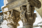 <center>Cloitre de St Trophime</center>galerie Nord. Chapiteau à deux rangs de feuilles d'acanthe; trois grosses têtes occupent la place des fleurons. Saint Paul devant l'Aréopage. Dans l'angle, un personnage à mi-corps jaillit de deux rangs de feuilles et occupe la place de la volute.