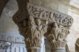<center>Cloitre de St Trophime</center>galerie Nord. Chapiteau à trois rangs de feuilles d'acanthe.
Chapiteau à deux rangs de feuilles d'acanthe. Trois têtes occupent la place du fleuron sur le dé ; Les deux  personnages soutiennent la volute Ouest dans leurs bras.