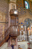 <center>St Nicolas de Myre. </center> Chaire à prêcher. Cuve hexagonale à panneaux marquetés séparés de colonnes accolées ; culot mouluré ; dosseret marqueté encadré de pilastres ; abat-voix hexagonal en forme d'entablement, couronné d'un dais formé de six montants chantournés.
