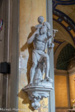 <center>L'église de La Trinité. </center> Saint Christophe de Lycie, représenté en pagne, sortant des eaux, portant l’enfant Jésus sur ses épaules, avec son bâton fleuri à la main. Statue petite-nature, en plâtre-stuc de Paris. Origine : « La statue religieuse », Paris,  entre 1921 et 1932, acquise probablement à l’occasion de la restauration de l’église en 1929-1932.