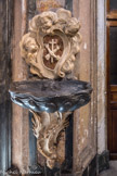 <center>Eglise Saint Théodore. </center>Bénitier ancien régime, de Fossati. Les deux bras sont un des symboles des Franciscains : le bras de saint François d’Assise croise celui du Christ. Les deux bénitiers sont de Dominique Fossati.
