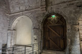 <center>Ancienne porte d'entrée de l'église, côté cloitre.</center>A gauche, la baie obstruée qui donnait la lumière aux cryptes.