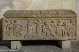 <center>Sarcophage de la Traditio legis. </center>Ce sarcophage, en travertin local vraisemblablement, muni de son couvercle a été découvert en 1971. C'est une production locale de la fin du XVe siècle ou du début du VIe. Il contenait la sépulture habillée et partiellement embaumée d'une jeune femme portant une croix d'or sur le front, objet attribué à l'orfèvrerie méditerranéenne du VIe siècle. Le décor en frise continue présente en son centre la Traditio legis (Don par le Christ de la Loi à Pierre en présence de Paul). A gauche, la scène du sacrifice d'Abraham. A droite la représentation du miracle de guérison d'un aveugle. Le décor du couvercle consiste en la représentation d'une pente de toiture en tuiles.