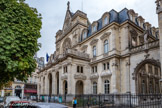 <center>Église Saint-Germain-l'Auxerrois.</center>L 'architecte Hittorff est chargé en 1855 de la construction de la mairie de l'arrondissement. Conçue comme une sorte de pendant à l'église, la mairie doit rappeler l'« aspect général » et la « silhouette » de celle-ci sans toutefois en reproduire les « formes » ni les « détails », le style de chacun des édifices devant en révéler la fonction.
On observe ainsi une symétrie des volumes : le porche de la mairie reproduit le rythme des cinq arcades du porche de l'église tandis que la rose flamboyante surmontée d'un pignon a été transposée dans la partie haute de la mairie. Au sommet des deux édifices se répondent les sculptures de Saint-Michel et de la Loi.