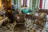 <center>Le château de Champs-sur-Marne. </center>Grand Salon. Le mobilier présenté ici comme dans le reste du château fut acheté par les Cahen d’Anvers sur différents marchés de l’art et du mobilier ancien (antiquaires ou salle des ventes, comme Drouot). On peut donc observer des éléments de mobilier d’époques différentes mais surtout du XVIIIe siècle (époque Régence, époque Louis XV et mobilier 1900 qui pastiche parfois le mobilier du XVIIIe siècle). Les fauteuils de tapisserie et les fauteuils en cuir datent du XVIIIe siècle. Le long du mur, on peut voir un canapé vert dit en ottomane devant lequel est placé un 
bureau à cylindre d’époque Louis XV (les meubles fabriqués au XVIIIe siècle sont dit «d’époque» et ceux fabriqués au XIXe siècle sont dit «de style»). Estampillé par Léonard Boudin, ce type de bureau est très apprécié au XVIIIe siècle car on pouvait refermer le couvercle en forme de quart de cylindre, afin de préserver les secrets qu’il contient sans avoir à ranger ses papiers. Il fut offert à Charles Cahen d’Anvers comme cadeau de mariage en 1907 et son emplacement montre la volonté du propriétaire d’exposer sa collection aux yeux du visiteur.