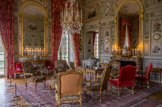 <center>Le château de Champs-sur-Marne. </center>Salon Chinois. Par la richesse de son décor, le salon chinois est une pièce majeure du château. Si cette pièce devait être originellement le cabinet de Madame, elle devint rapidement un salon d’assemblée où on se réunit pour jouer aux cartes et discuter. Des tables de jeux (tric-trac, cartes) sont d’ailleurs exposées de part et d’autre de la cheminée. Mais il semble plus probable que les Cahen d’Anvers en fassent une pièce d’apparat à faire visiter aux invités. Dans les années 1960, les chefs d’Etat invités y regardent la télévision. Les six fauteuils de style Louis XV, le tabouret, le canapé et l’écran en bois face à la cheminée datent du XIXe siècle. Ils ont été recouverts de tapisseries du XVIIIe siècle provenant de la manufacture de Beauvais et représentant des fables de La Fontaine, inspirés des gravures d’Oudry. Les rideaux ont été retissés d’après le modèle posé par les Cahen d’Anvers, des lampas de chinoiseries sur fond rouge. Des sous-rideaux blancs ont été replacés au moment de la restauration pour rappeler les sous-rideaux de soie brodée installés par les Cahen d’Anvers.