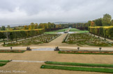 <center>Le château de Champs-sur-Marne. </center>Vue du salon de musique. Au centre, encadrées par une double rangées de tilleuls, les broderies dessinent des formes géométriques subtiles et colorées. Des topiaires émergent des massifs fleuris pour donner une dimension verticale à cette composition horizontale. Au fond, le groupe sculpté des Chevaux d’Apollon, copie dix fois plus grande d’un groupe qui ornait la grotte de Thétis à Versailles.