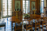 <center>Le château de Malmaison. </center> La Salle a manger. Au somptueux dallage de marbre noir et blanc, dont les carreaux forment dans l'hémicycle un demi-cercle en étoile à cinq branches, répond un décor peint faisant référence à l'Antiquité: huit grandes figures de danseuses de style pompéien peintes sur stuc par Louis Lafitte d’après des dessins de Percier. Table en acajou, aux Tuileries sous l’Empire, Jacob-Desmalter. Douze chaises livrées pour le palais des Tuileries Jacob Frères, vers 1800. Deux candélabres en bronze doré, Thomire.