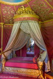 <center>Le château de Malmaison. </center> Chambre de Joséphine de Beauharnais. L’Impératrice rendit le dernier soupir dans la splendide couchette livrée pour la pièce en 1812 par Jacob-Desmalter. Le lit, de même que les sièges, fut livré par Jacob-Desmalter, mais c'est très vraisemblablement Berthault qui fournit le dessin de la couchette, assez proche de celle qu'il dessina peu de temps auparavant pour l'impératrice à Compiègne. Le lit, à deux chevets inégaux, est porté par quatre pieds formés par la pointe de cornes d'abondance. A la tête, les cornes sont surmontées de deux grands cygnes, ailes dressées et cou replié; au pied, les cornes sont remplies de fleurs et de fruits. Sur la traverse sont sculptés de larges rinceaux se terminant par des fleurs de lotus d'où s'échappe une épaisse guirlande de fleurs au centre de laquelle un médaillon contient le monogramme J.