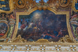 <center>La galerie des Glaces. </center> La Franche-Comté conquise pour la seconde fois, 1674. La Franche-Comté avait été conquise une première fois en quinze jours lors de la guerre de Dévolution, du 3 au 19 février 1668. La province avait été rendue à l’Espagne à l’issue du traité d’Aix-la-Chapelle. De nouveau conquise entre février et mai 1674 (la citadelle de Besançon fut prise le 22 mai 1674), elle demeura française. Le roi est immobile au milieu du tumulte. Comme dans le tableau de la Prise de Gand, les villes conquises sont peintes comme des jeunes femmes éplorées. Elles sont traînées devant le roi par Mars qui lui présente leurs écus. Le rocher escaladé par Hercule et Minerve à l’arrière-plan symbolise la citadelle de Besançon.