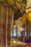 <center>La chambre de la Reine.</center> Vue de la porte gauche de l'alcôve. Au-dessus de la porte, La Gloire des Princes s'empare des Enfants de France de Troy (de), Jean-François, 1734. Commandé pour Marie Leczinska. Au-dessus du miroir, Marie-Thérèse de Habsbourg, mère de  Marie-Antoinette, Manufacture des Gobelins (fabricant)
atelier de Cozette, Michel-Henri (lissier)
d'après Ducreux, Joseph (peintre).