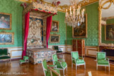 <center>La chambre du Dauphin.</center> Cet ancien cabinet doré de Monseigneur, dont le plafond avait été peint par Mignard, servait de salle d’exposition à la collection de tableaux du fils de Louis XIV. Le Régent, qui en fera son cabinet de travail, y décédera le décembre 1723. La pièce agrandie et transformée en chambre à coucher en 1747, a conservé son décor composé de boiseries en bois sculpté par Verberckt sur des dessins de Gabriel, la cheminée en griotte ornée de figures de bronze doré de Flore et Zéphyr exécutées par Jacques Caffieri. Le lit du Dauphin ayant disparu, il a été remplacé par un lit « à la duchesse » – c’est-à-dire un lit dont l’impériale n’est pas soutenue par des piliers mais suspendue – exécuté vers 1740 pour la marquise de Créquy ; ses étoffes sont ornées de motifs de rinceaux et de médaillons réalisés au petit point ; celui du dosseret représente Le sommeil du berger Endymion. Portraits de la première épouse du Dauphin, l’infante d’Espagne et de ses parents le roi Philippe V et la reine Elisabeth.