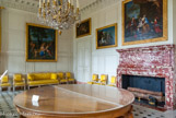 <center> Le Grand Trianon.</center> Le salon des Seigneurs. Antichambre des Seigneurs aux XVIIème et XVIIIème siècles, salle à manger pour la suite de Madame Mère sous l’Empire, puis pour l’impératrice Marie-Louise, elle deviendra la chambre des Huissiers de la reine Marie-Amélie sous Louis-Philippe. La grand table à plateau de teck (ou chêne de Malabar) a été réalisée en 1823 par Félix Rémond. Au-dessus de la cheminée, le ableau représentant Le Grand Dauphin et sa famille. Copie d'une œuvre de Pierre Mignard, peinte en 1693 par Jérémie Delutel à la demande du duc d'Orléans, elle représente le fils de Louis XIV, entourée de sa femme, Marie-Anne de Bavière, et de leurs trois enfants: Louis, duc de Bourgogne, Philippe, duc d'Anjou et Charles, duc de Berry. A gauche de la cheminée, Minerve et Tirésias, de René-Antoine Houasse, 1698. Sur le mur du fond, Vénus prenant congé d'Adonis, de François Verdier, 1696.