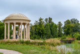 <center> Le Temple de l’Amour.</center> Dès 1777, Richard Mique travaille sur les plans de l’édifice. Le 5 mai, il présente à la reine une maquette de bois, de plâtre et de cire réalisée selon ses instructions par le sculpteur Joseph Deschamps. Contrairement à son habitude, Marie-Antoinette accepte d’emblée le projet sans restriction aucune.
L’édifice, bâti sur une île de la rivière, se dresse sur un socle auquel conduisent sept marches. Douze colonnes corinthiennes soutiennent une coupole surbaissée en pierre de Conflans, couverte de plomb peint en imitation de la pierre. L’entablement est composé d’une architrave au soffite décoré de rosaces, d’une frise d’arabesques, à l’intérieur comme à l’extérieur, et d’une corniche composite. Le sol du temple est l’œuvre du marbrier Le Prince et se compose de marbre blanc veiné, de rouge de Languedoc et de marbre de Flandre. La construction débute aussitôt pour être achevée en juillet 1778. La maçonnerie a été exécutée par Guiard.