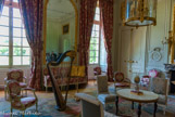 <center> Le Petit Trianon.</center> Le salon de compagnie. Pièce principale de l’étage, salon de compagnie, des jeux et de musique en particulier du temps de Marie-Antoinette. Honoré Guibert a sculpté les trophées de musiques des lambris ornés du chiffre du roi Louis XV, les deux L en feuille de myrthe enlaçant trois fleurs de lys au naturel sous une couronne de roses. L’imposante cheminée est en brèche violette.
Le décor textile est un « damas trois couleurs » de Lyon souvent utilisé dans les châteaux royaux au XVIIIème. Petite table à thé de B. Molitor. sur lequel est posé un oeuf d'autruche peint par J.E. Lebel. Sièges deG.  Jacob.