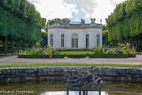 <center> Le Pavillon français.</center> Le premier architecte a imaginé un plan combinant une vaste rotonde flanquée de quatre petites ailes. L’ensemble, couronné d’une balustrade dissimulant les toitures, plaît tout particulièrement au roi qui aime à en faire les honneurs. La distribution intérieure est simple : un salon octogonal, autour, quatre petites pièces ; un boudoir, une cuisine, un réchauffoir et une garde-robe. Les groupes sculptés de la toiture, de Jules-Antoine Rousseau, représentent huit groupes d’enfants symbolisant chacun une saison ou un élément.