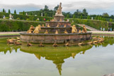<center>Les jardins de Versailles.</center> Le bassin de Latone. Le groupe central en marbre, sculpté par les frères Marsy, représente Latone et ses enfants. Elle aurait voulu laver dans une source, mais des bergers l'en empêchèrent. Latone implora Zeus qui les transforma en grenouilles. Le groupe était, lors de la création du bassin en 1668, placé sur un rocher et entouré des six figures de paysans en train de se transformer, tandis que vingt-quatre grenouilles étaient disposées sur la plate-forme de gazon entourant le bassin. La déesse regardait alors vers le Château. Cet aménagement fut modifié par Jules Hardouin-Mansart entre 1687 et 1689. Le rocher fit place à une pyramide de marbre et le groupe de Latone regarde désormais vers le Grand Canal.