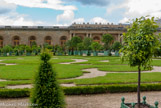 <center>Les jardins de Versailles.</center> L’Orangerie. La galerie centrale et la terrasse du parterre du midi. Les murs, de 4 à 5 mètres d’épaisseur, les doubles vitrages des baies et l’exposition au Midi permettent de maintenir l’hiver une température qui ne descend pas au-dessous de 5° C. Pour peupler l’Orangerie, Louis XIV rassemble tous les orangers des maisons royales et multiplie les acquisitions de nouveaux sujets en Italie, en Espagne et au Portugal. Il est alors de bon ton chez les courtisans, pour faire leur cour au roi, d’offrir leurs propres orangers.