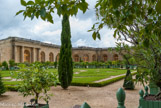 <center>Les jardins de Versailles.</center> L’Orangerie. Le château de Versailles est doté d’une orangerie dès 1663, bâtie par Louis Le Vau. L’emplacement est excellent : orientée plein sud, elle est protégée du froid des vents dominants par sa position sous le parterre du Midi. Vingt ans plus tard, Jules Hardouin-Mansart double la longueur de cette première orangerie, ainsi que sa largeur, pour en faire un immense édifice. La galerie centrale est longue de plus de 150 mètres et sa voûte culmine à 13 mètres de haut. Deux galeries en retour s’achèvent sous les escaliers monumentaux des Cent-Marches (à gauche) qui jouent le rôle de contreforts à l’ensemble.