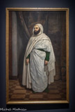 <center>Abd el-Kader</center>Jean Baptiste Ange Tissier (1814-1876).
1853.
Huile sur toile.
Musée national des châteaux de Versailles et de Trianon.
Peintre officiel du Second Empire, Ange Tissier exécute le portrait en pied d’Abd el-Kader juste après la libération de l’émir par Napoléon III. Représenté devant une tenture du château de Chambord, Abd el-Kader pose noblement, drapé dans son double burnous blanc, le regard détourné, un chapelet à la main, sans se livrer tout à fait. Le peintre a pu s’inspirer du portrait photographique de Gustave Le Gray.